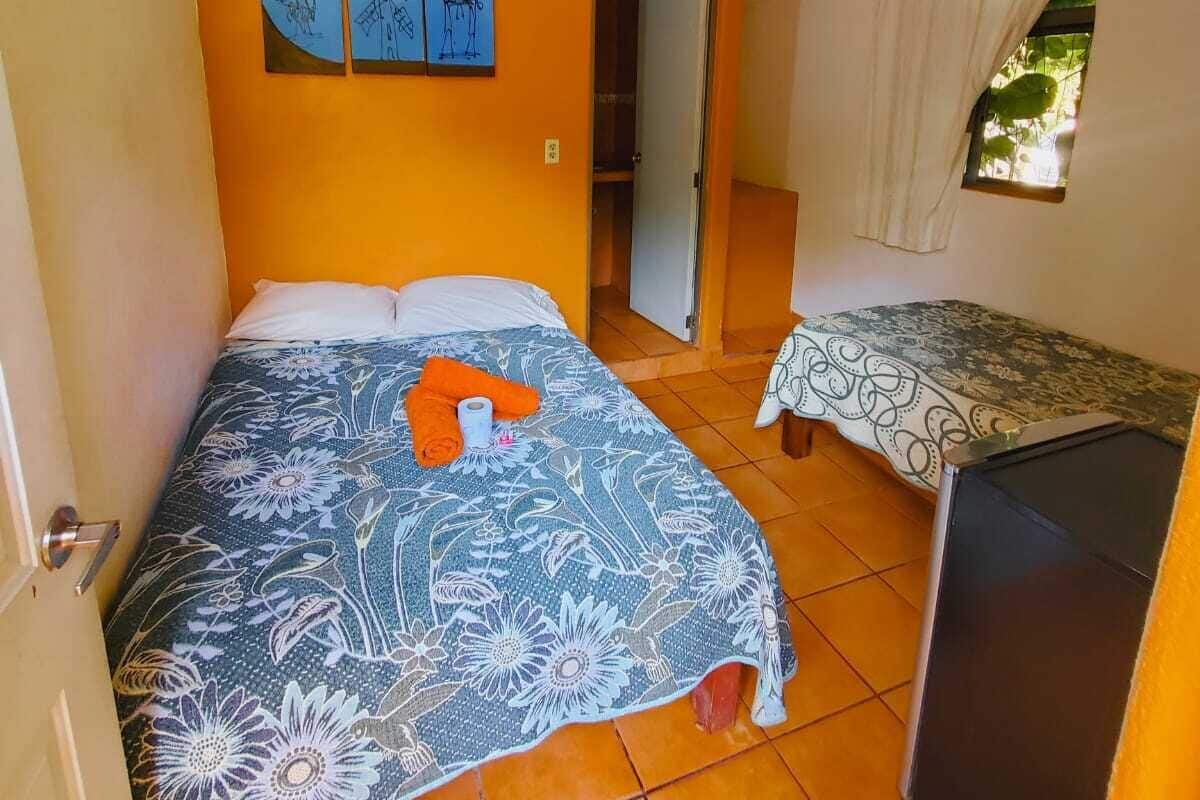 A room with a bed, a small table, and a window.
