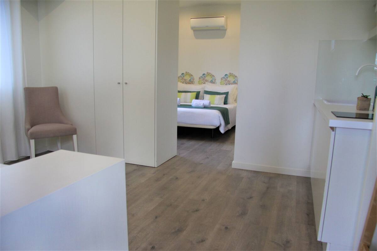 Ein Schlafzimmer mit einem Bett, einem Sessel und einem kleinen Tisch.