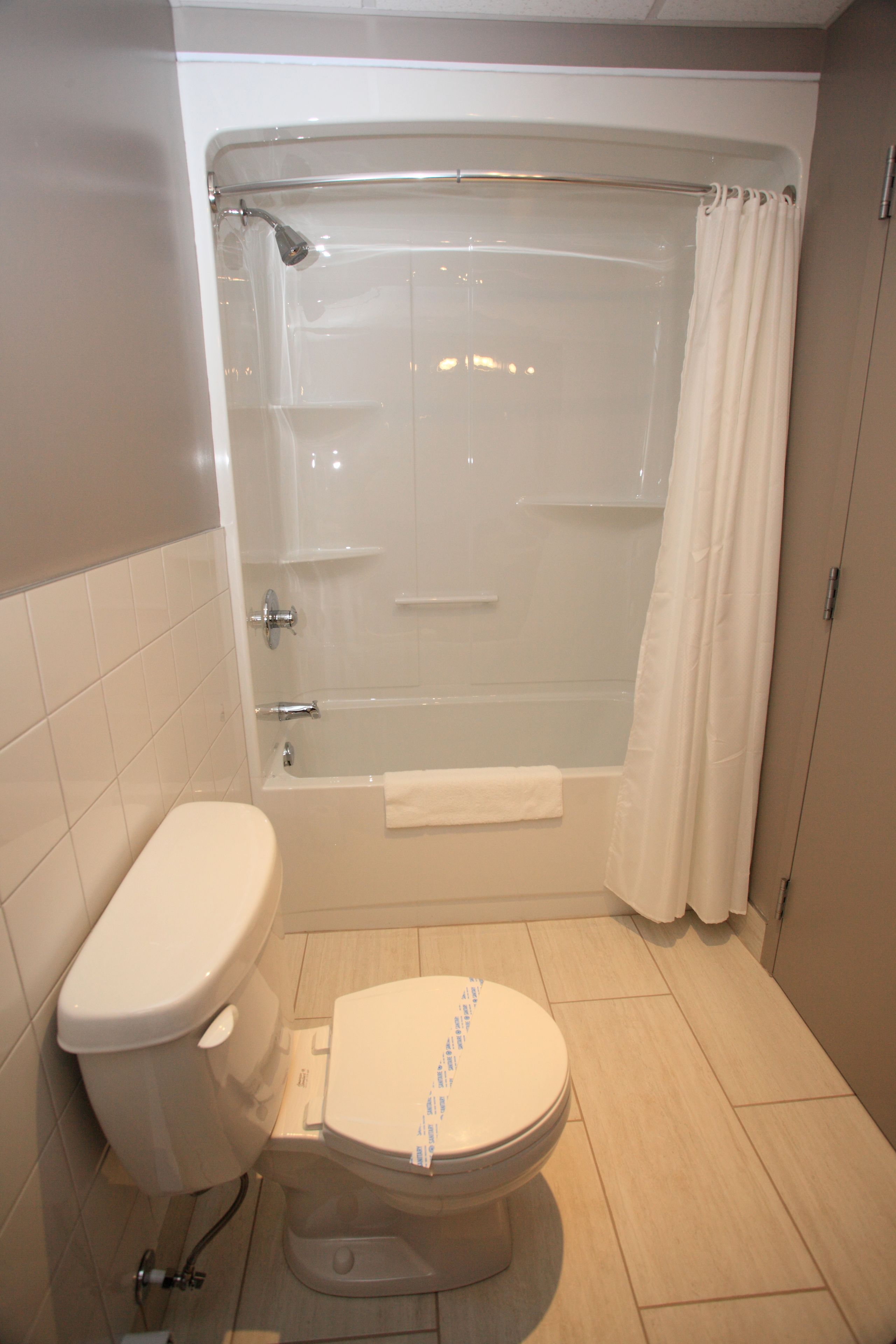 A bathroom with a toilet, bathtub, and shower curtain.