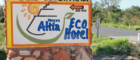 Señal para el Hotel Eco Nueva Althia, con una flecha indicando la entrada.