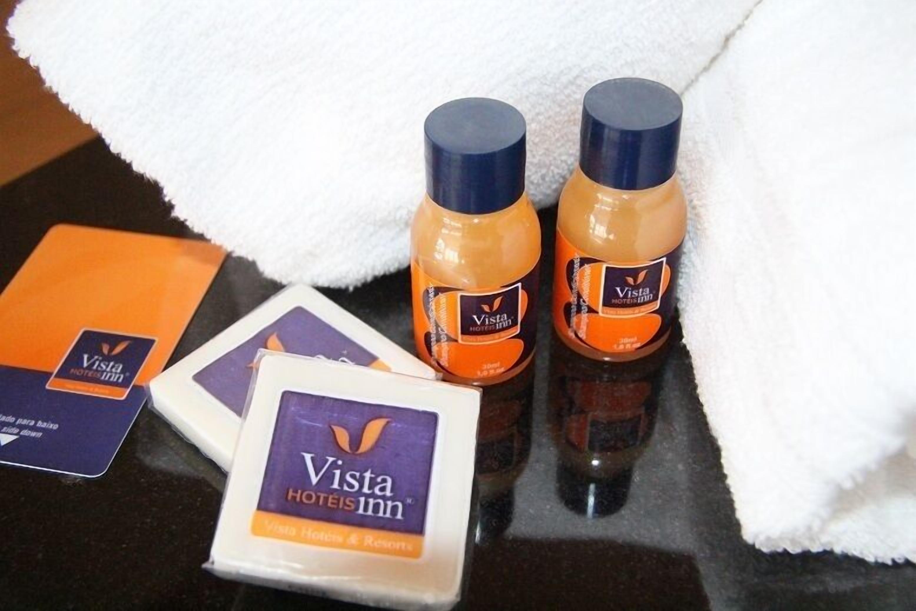Two bottles of lotion and a card with the Vista Hotels Inn logo.