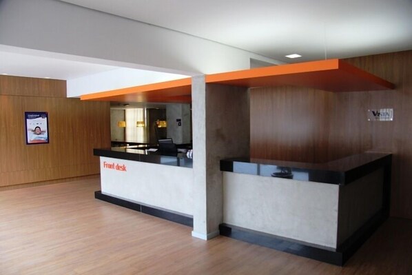 A reception area with a front desk, wooden panel walls, and a wooden floor. - Vista Inn Express Contagem (Contagem)