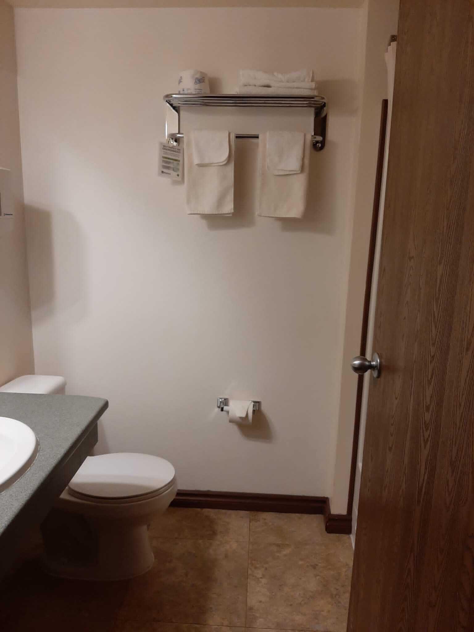 Un baño pequeño con un inodoro, un lavamanos y un perchero para toallas.