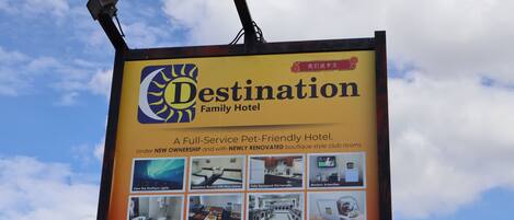 A Destination Family Hotel signboard with amenities like luxurious rooms, modern amenities, and a pet-friendly environment.