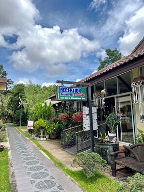 Ett entréområde med en skylt som visar att det finns en restaurang här som serverar thailändsk och internationell mat.