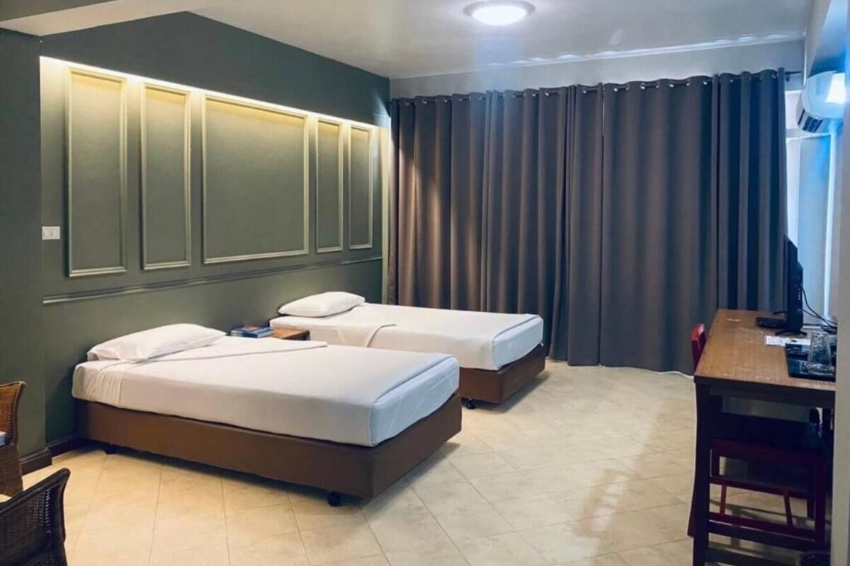 A hotel room with two beds, a desk, and a chair.