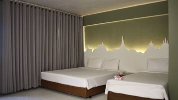Habitación de hotel con dos camas, un mural con un paisaje urbano en la pared y un ventanal con cortinas.