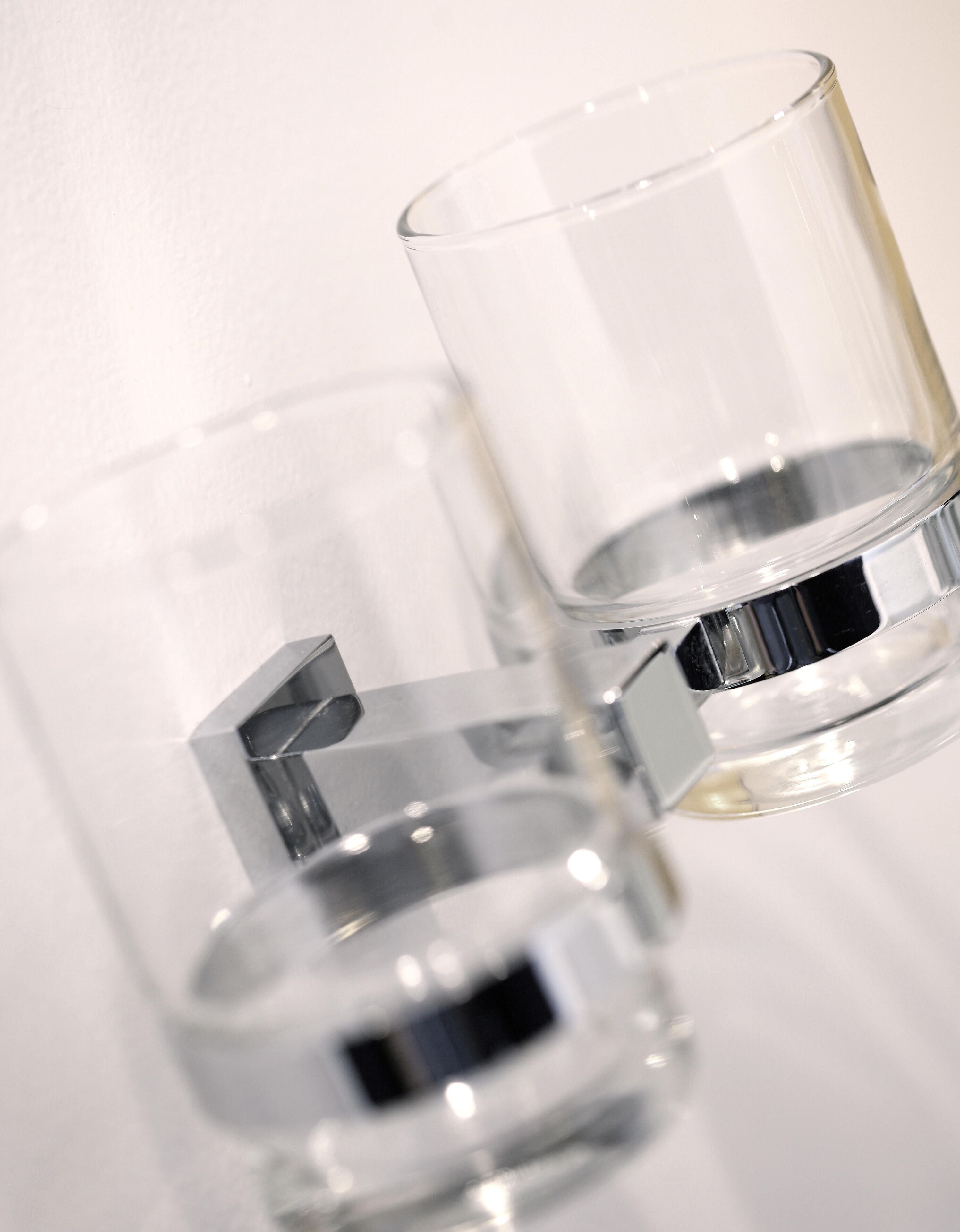 Two clear glasses with a metallic base, placed against a white background.