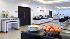 A modern kitchen with a buffet setup, including a bowl of eggs and a coffee station.
