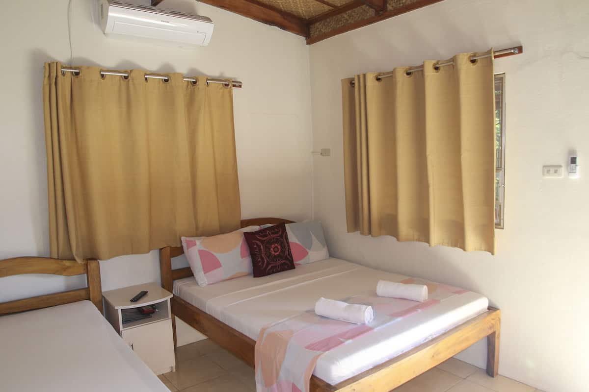 A bedroom with a bed, bedside tables, and curtains.