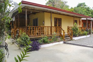 A yellow building with a red roof, wooden balcony, and surrounding plants. - Isla Hayahay Beach Resort and Restaurant (Calape)