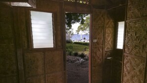 A room with a wooden door leading outside, a tiled floor, and a window with blinds. - Isla Hayahay Beach Resort and Restaurant (Calape)