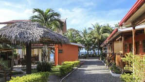 A pathway leading to a building with a thatched roof and a reception area. - Isla Hayahay Beach Resort and Restaurant (Calape)
