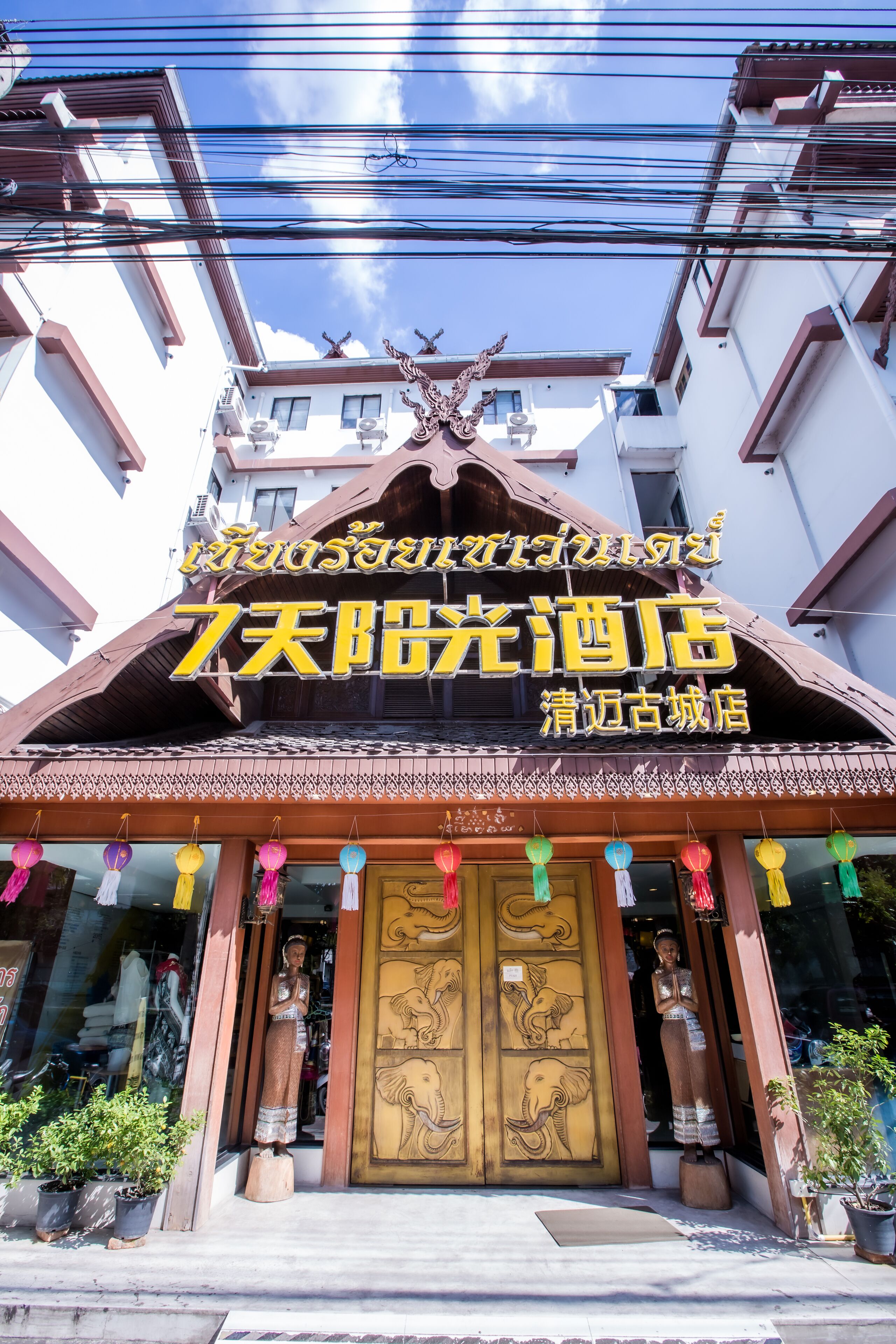 A hotel with a traditional architectural style, featuring a prominent entrance with decorative elements and a sign in a foreign language.