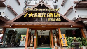 A hotel entrance with a traditional Thai architectural style, a signboard with Thai script, and a green mat at the entrance. - Chiang Roi 7 Days Inn (Chiang Mai)