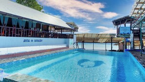 Una piscina con vista al mar, un área de descanso cubierta y un cartel que dice "ANDA DE BORACAY".