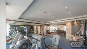 A gym with treadmills, weight machines, and a mirror wall. - Hawthorn Suites by Wyndham Abu Dhabi City Centre (Abu Dhabi)
