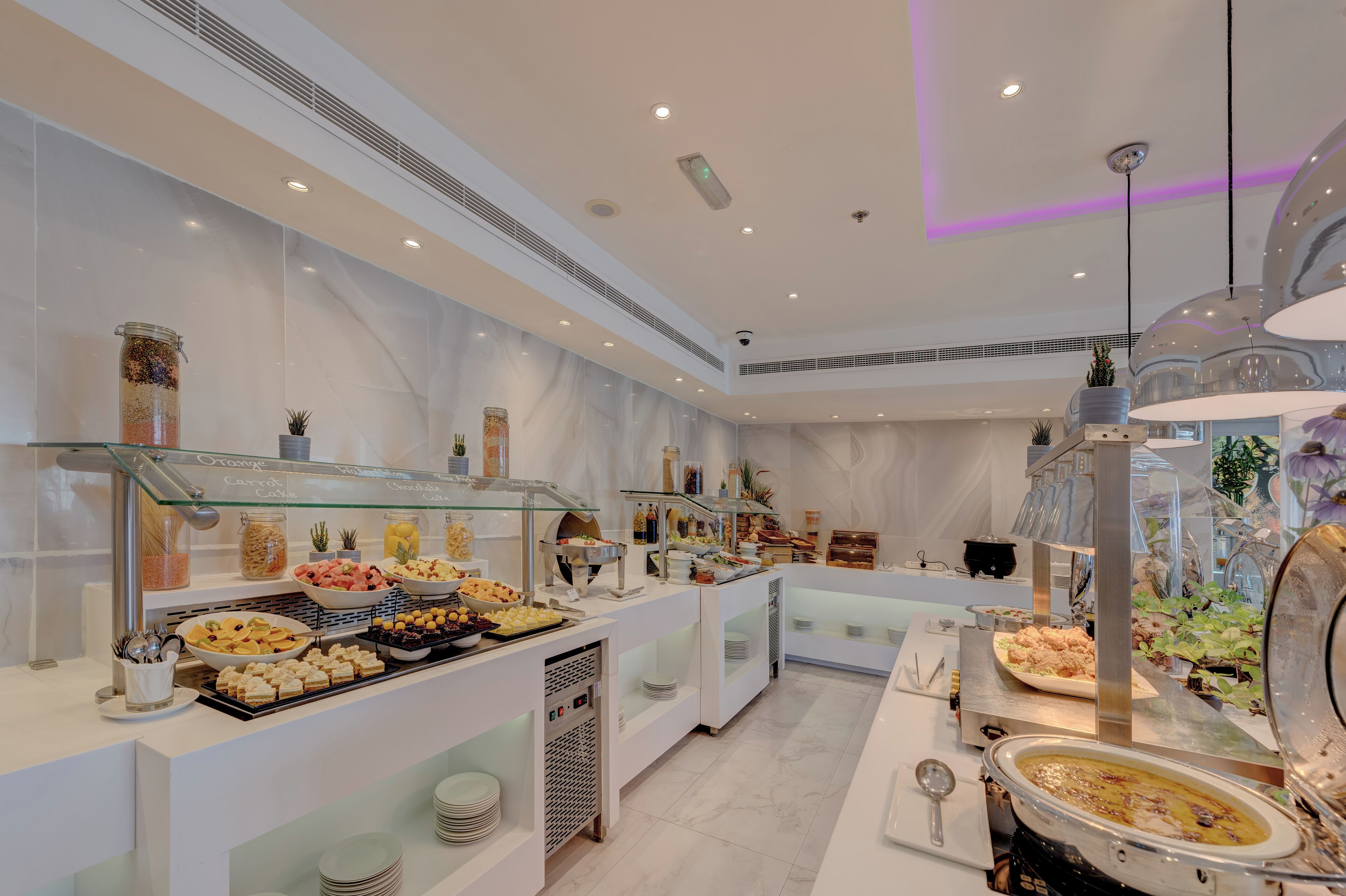 A buffet with various food items and a modern interior design.