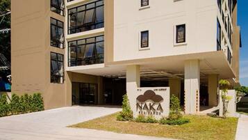 A modern building with a flat roof, multiple windows, and a sign with a logo.