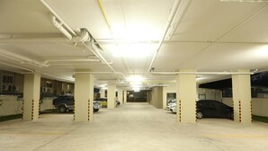 A multi-level parking garage with concrete floors and white pillars. - Naka Residence (Wichit)