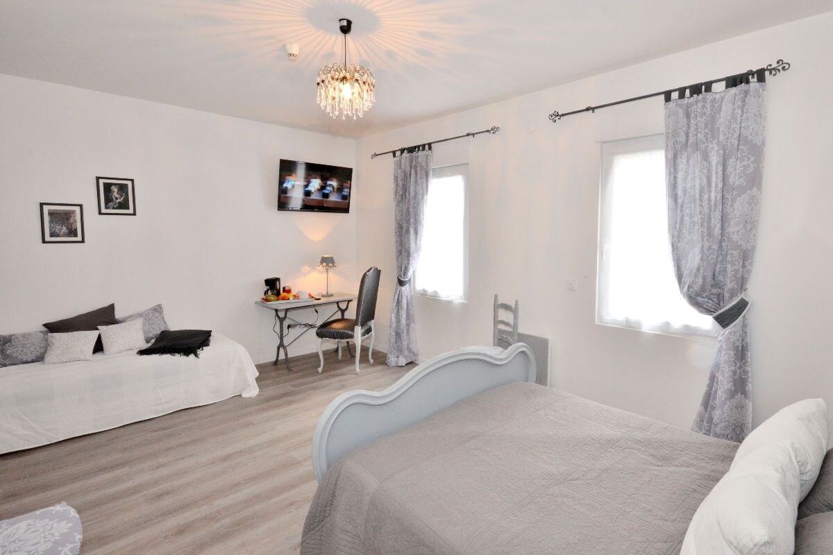 Un dormitorio con dos camas, un escritorio y una silla.