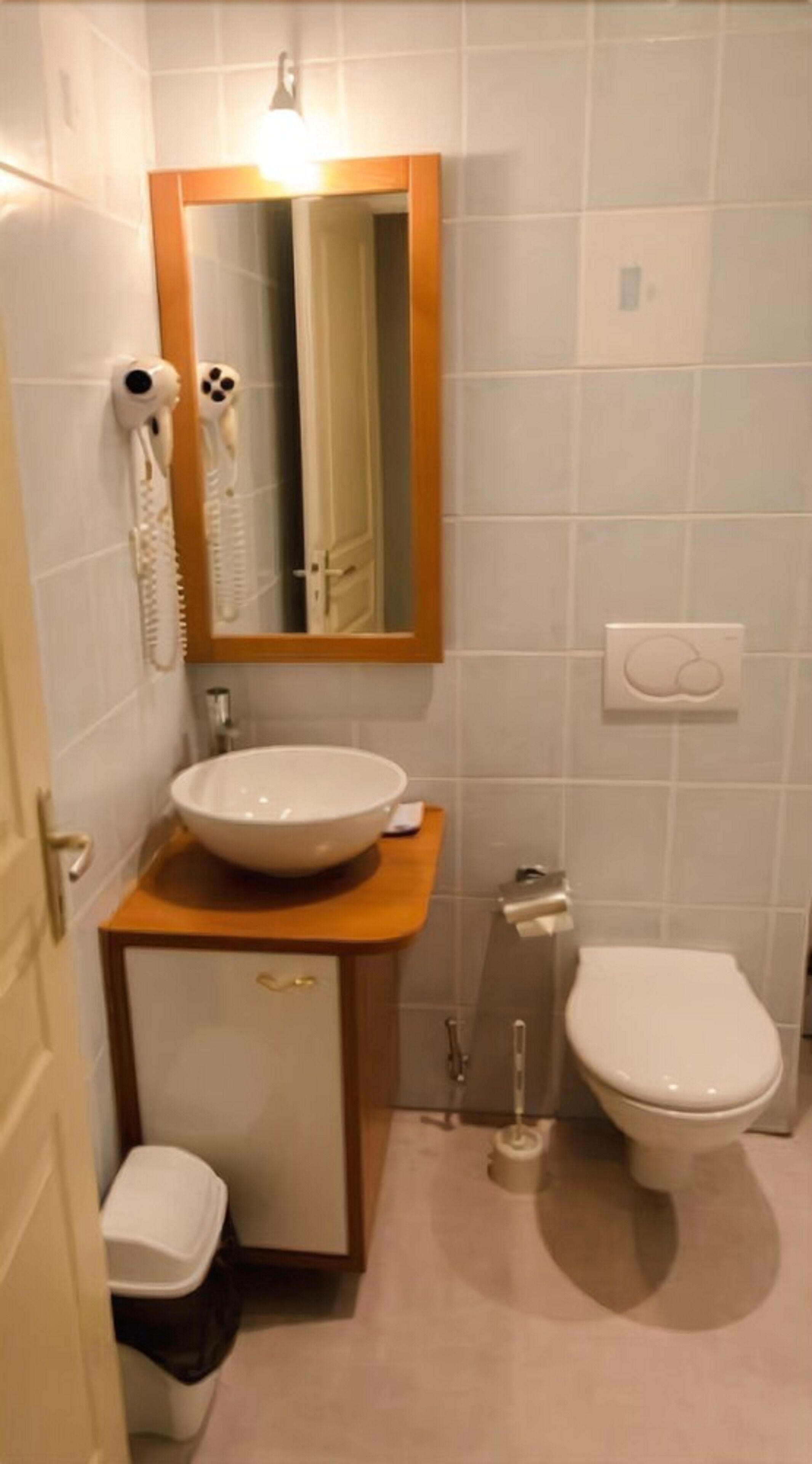 A small bathroom with a white sink, a toilet, and a mirror above the sink.
