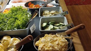 Een buffet met diverse soorten eten, zoals groenten, vlees en aardappelen.