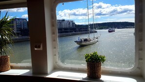 Uitzicht vanuit een raam, met een plant in een bloempot op het raamkozijn.