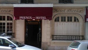De ingang van Hotel Phénix, met een bordeauxkleurig luifel en een bord boven de deur.