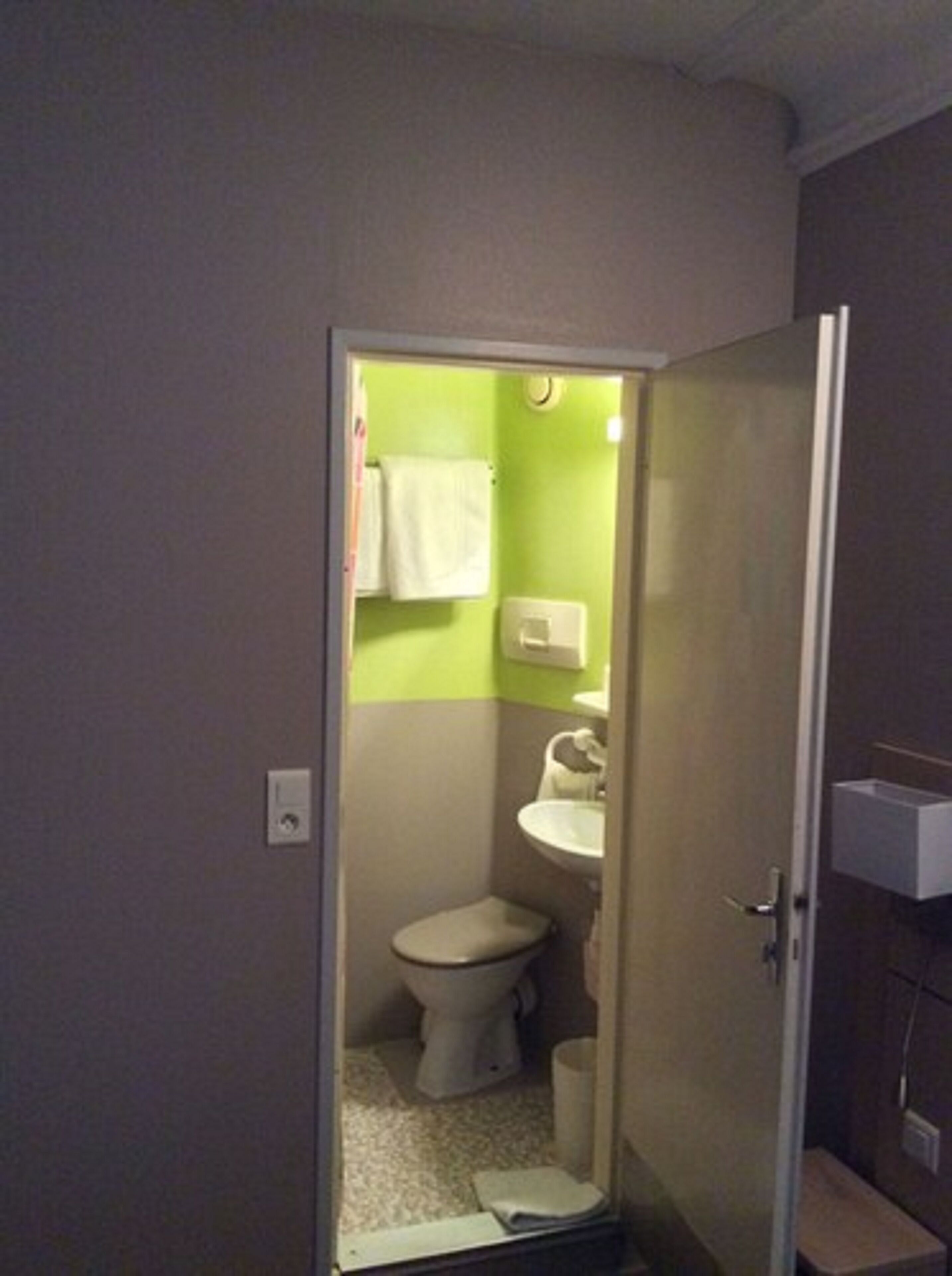 Une petite salle de bain avec des toilettes, un lavabo et un miroir.