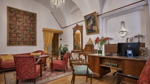 A traditional room with a large bookshelf, a wooden desk, and classic furniture. - Little King Hotel U Malvaze (Prague)