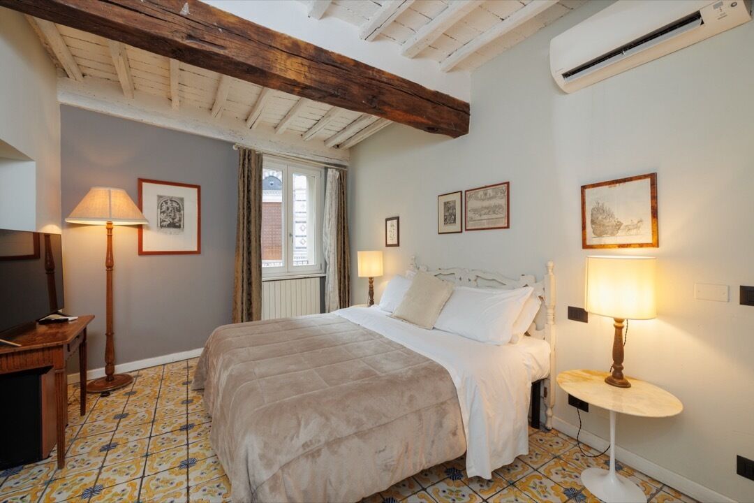 Une chambre à coucher avec un lit, deux lampes de chevet, un bureau et une fenêtre.