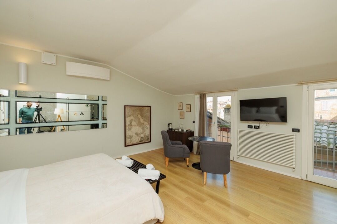 Ein Hotelzimmer mit Bett, Fernseher, Schreibtisch und Stuhl.
