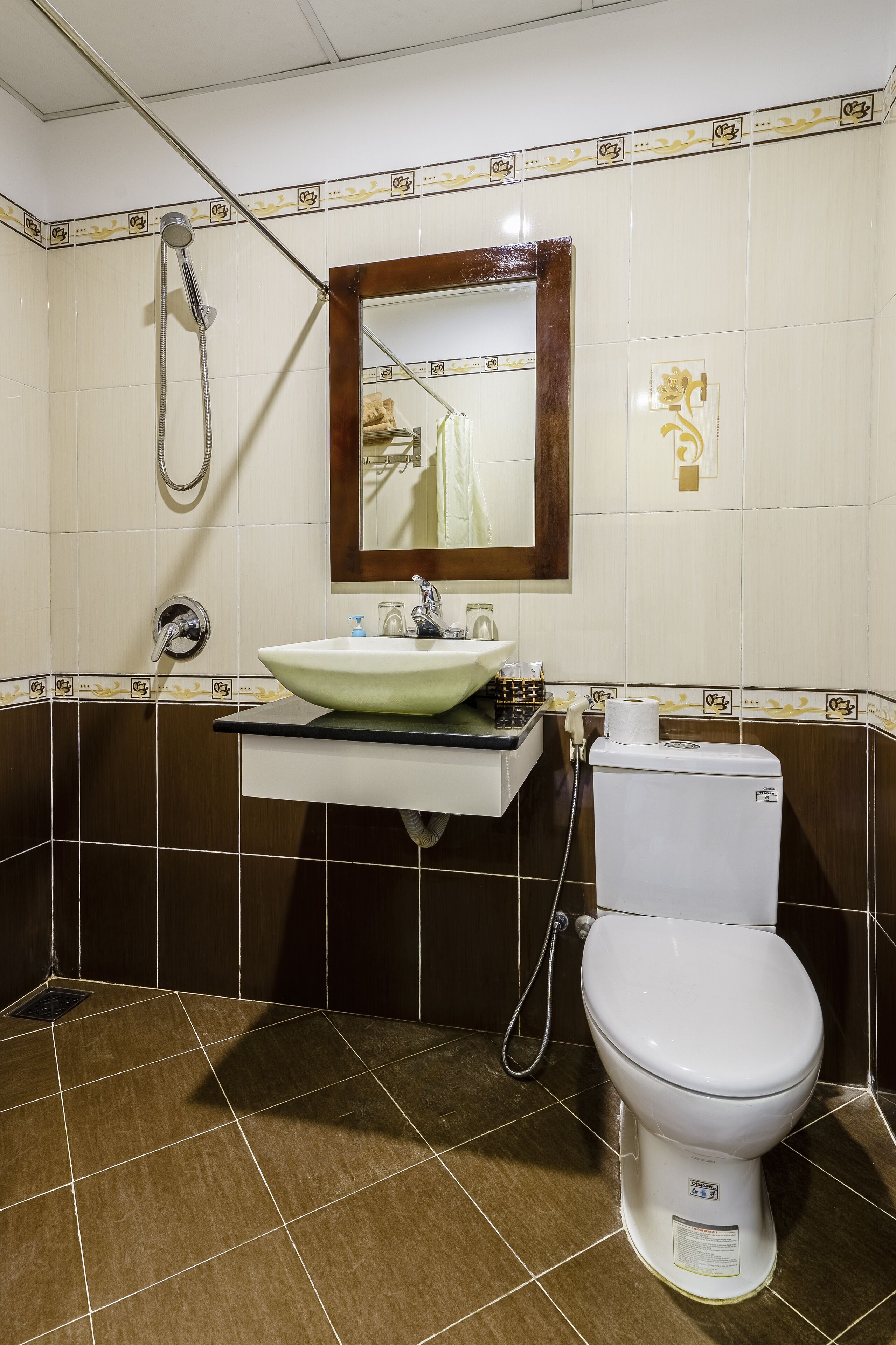 Une salle de bain équipée d’un lavabo, d’un miroir, de toilettes et d’une douche.