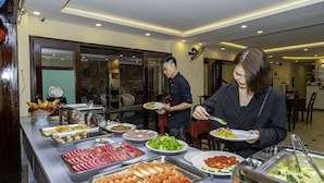 A buffet with various food options including meats, salads, and fruits. - Golden River Hotel (Da Nang)