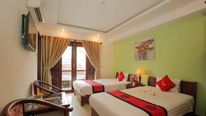 A hotel room with two beds, a dining table with chairs, a TV, and a window with curtains. - Golden River Hotel (Da Nang)