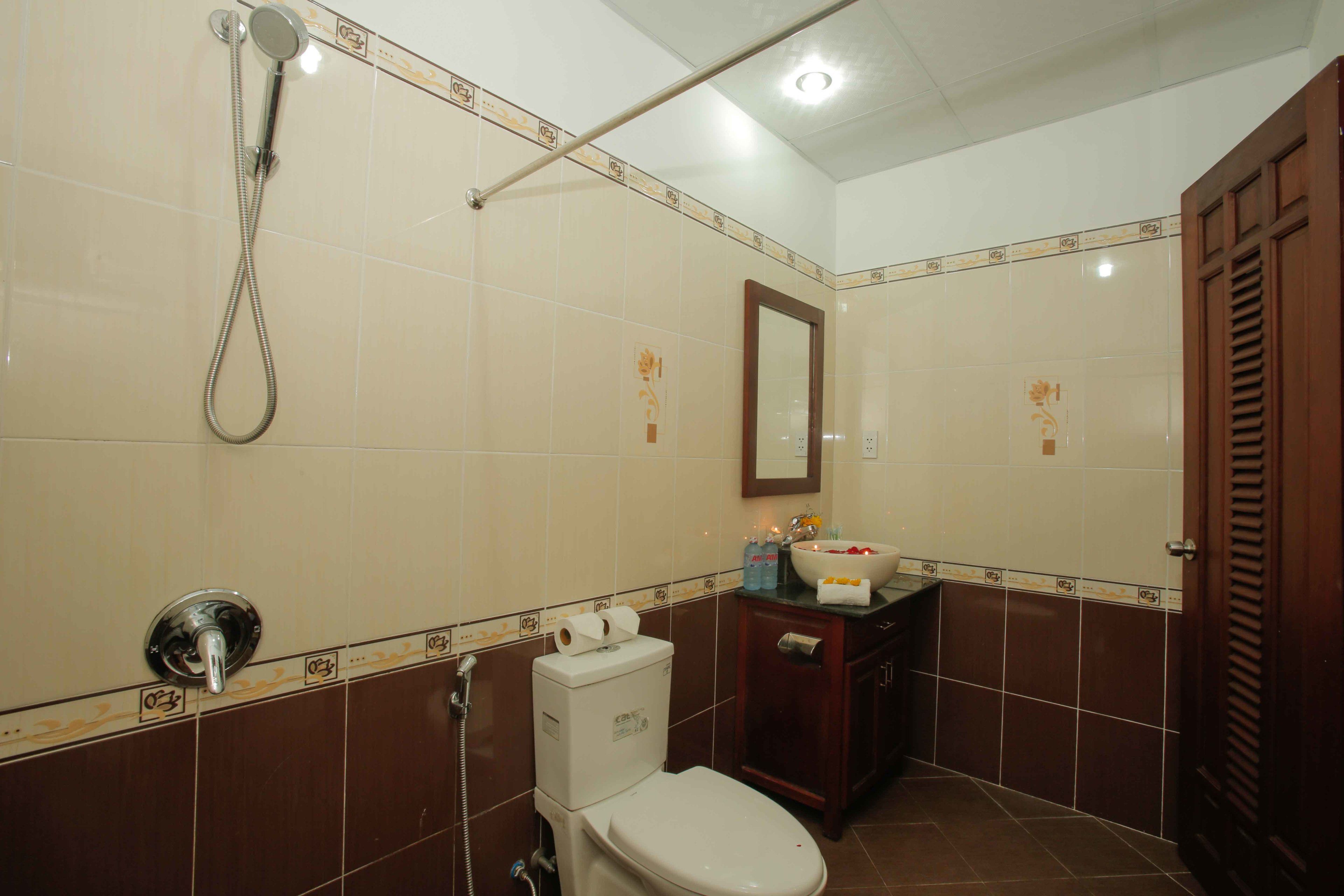 Ein Badezimmer mit Toilette, Waschbecken, Spiegel und Dusche.