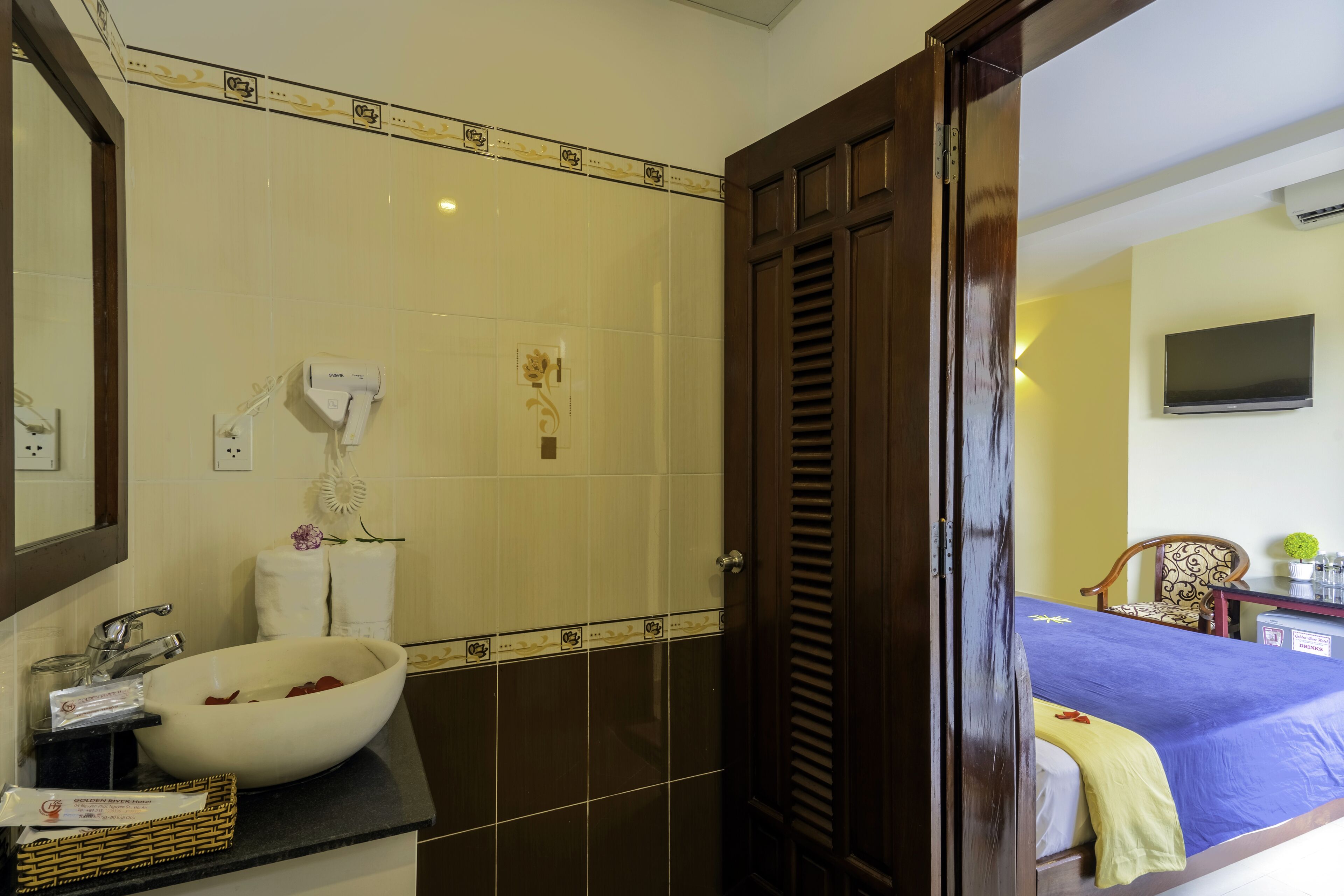 A bathroom with a large sink, a mirror, a towel rack, and a shower area.