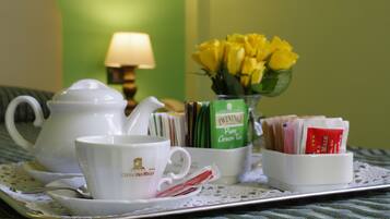 Una bandeja con tetera, tazas y una caja de té sobre una mesa con un mantel de encaje.