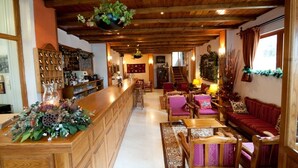 Un interior de madera con una zona de bar, asientos y una escalera que sube a otro nivel.