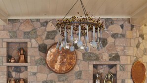 Un comedor acogedor con chimenea de piedra, sillas de madera y una mesa lista para dos.