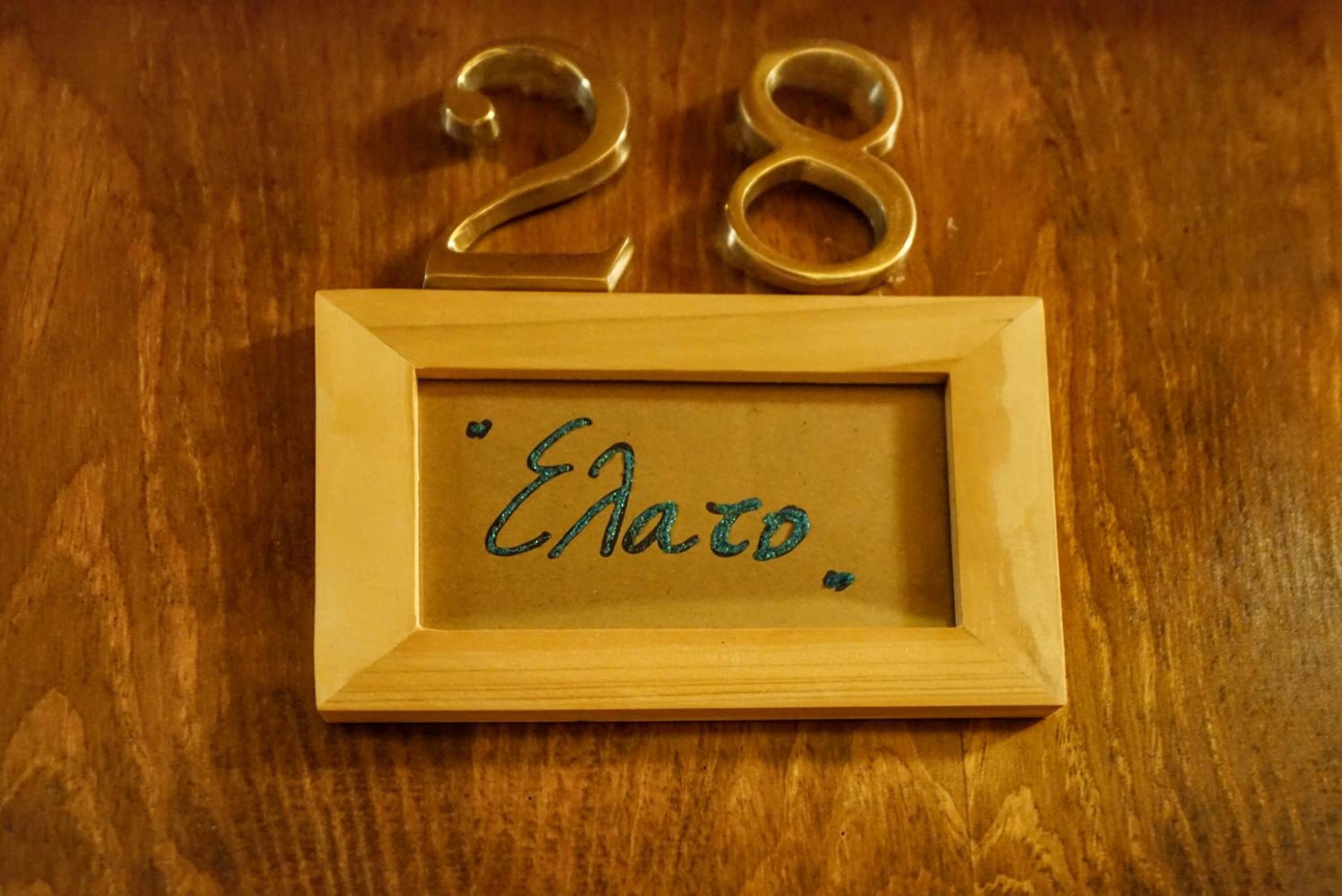 A wooden frame with the number 28 and the name "Elena" engraved on it.
