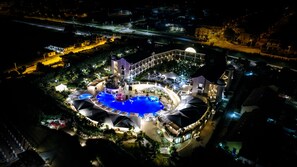 An aerial view of a resort with a central pool, multiple buildings, and surrounding greenery. - Grand Hotel Balestrieri (Melissa)