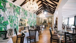 A restaurant with wooden floors, white tablecloths, and patterned chairs. - Endless Vineyards at Wildekrans Wine Estate (Bot River)
