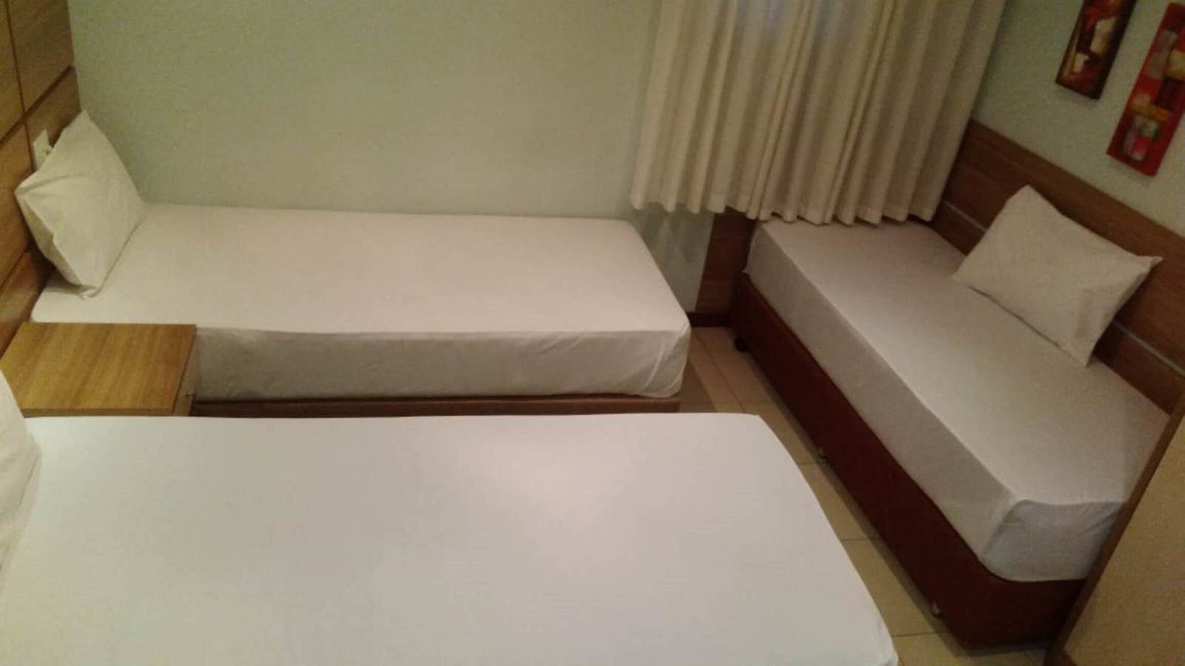 A room with two single beds and a sofa bed.