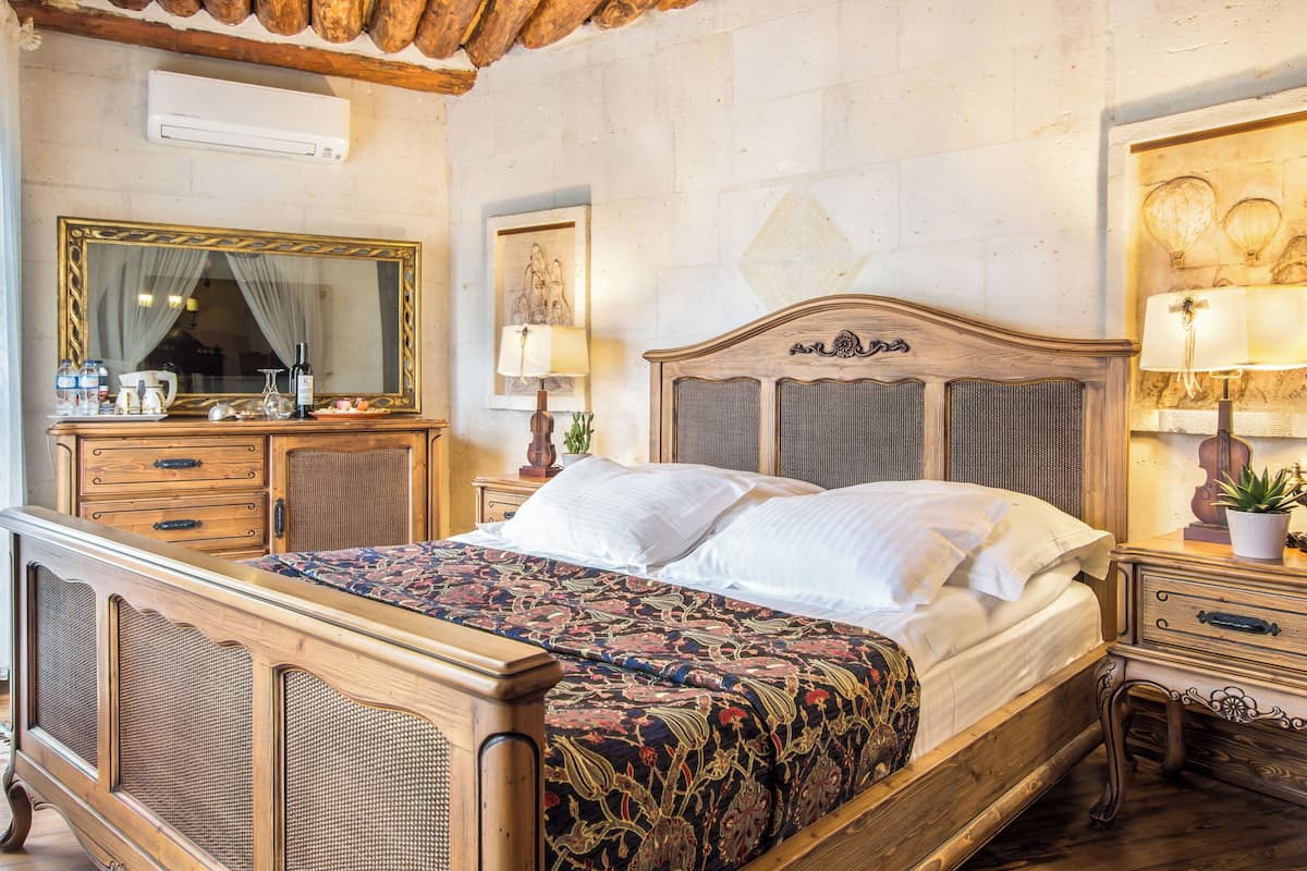 Una habitación tradicional con una cama de madera, un aparador, un espejo y una lámpara.
