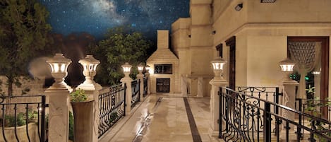 A nighttime view of a building with a starry sky, a stone pathway, and decorative lanterns.