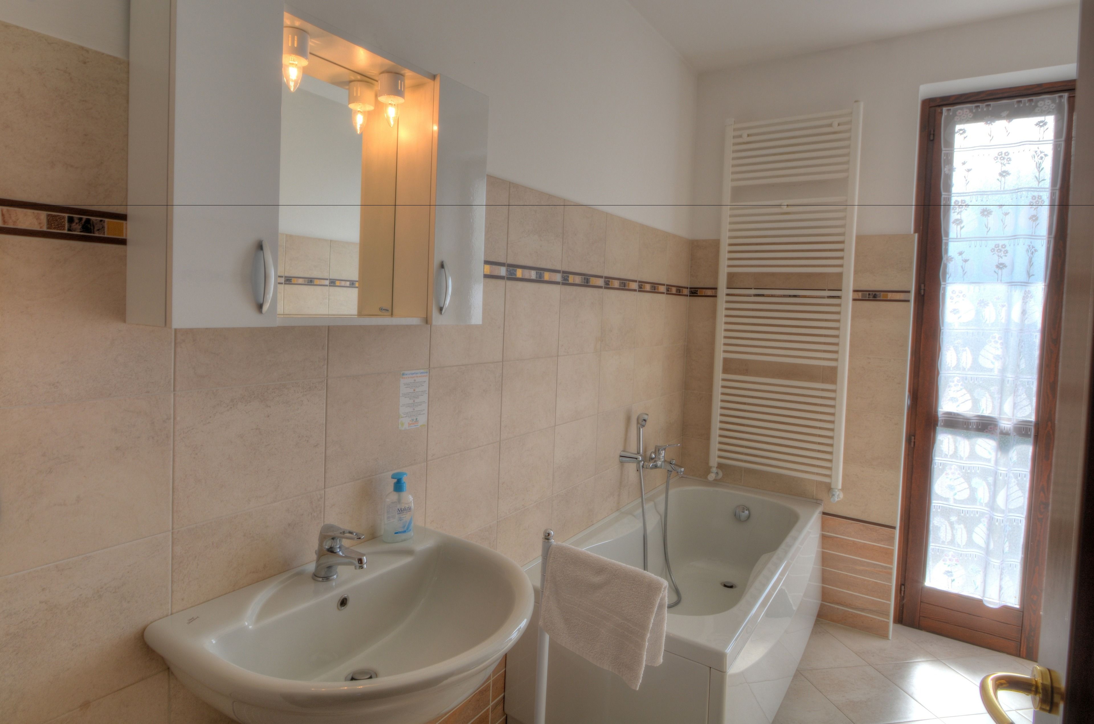 A bathroom with two sinks, a bathtub, a mirror, and a shower.