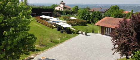 Un patio con mobiliario exterior, piscina y vistas a una iglesia y colinas.