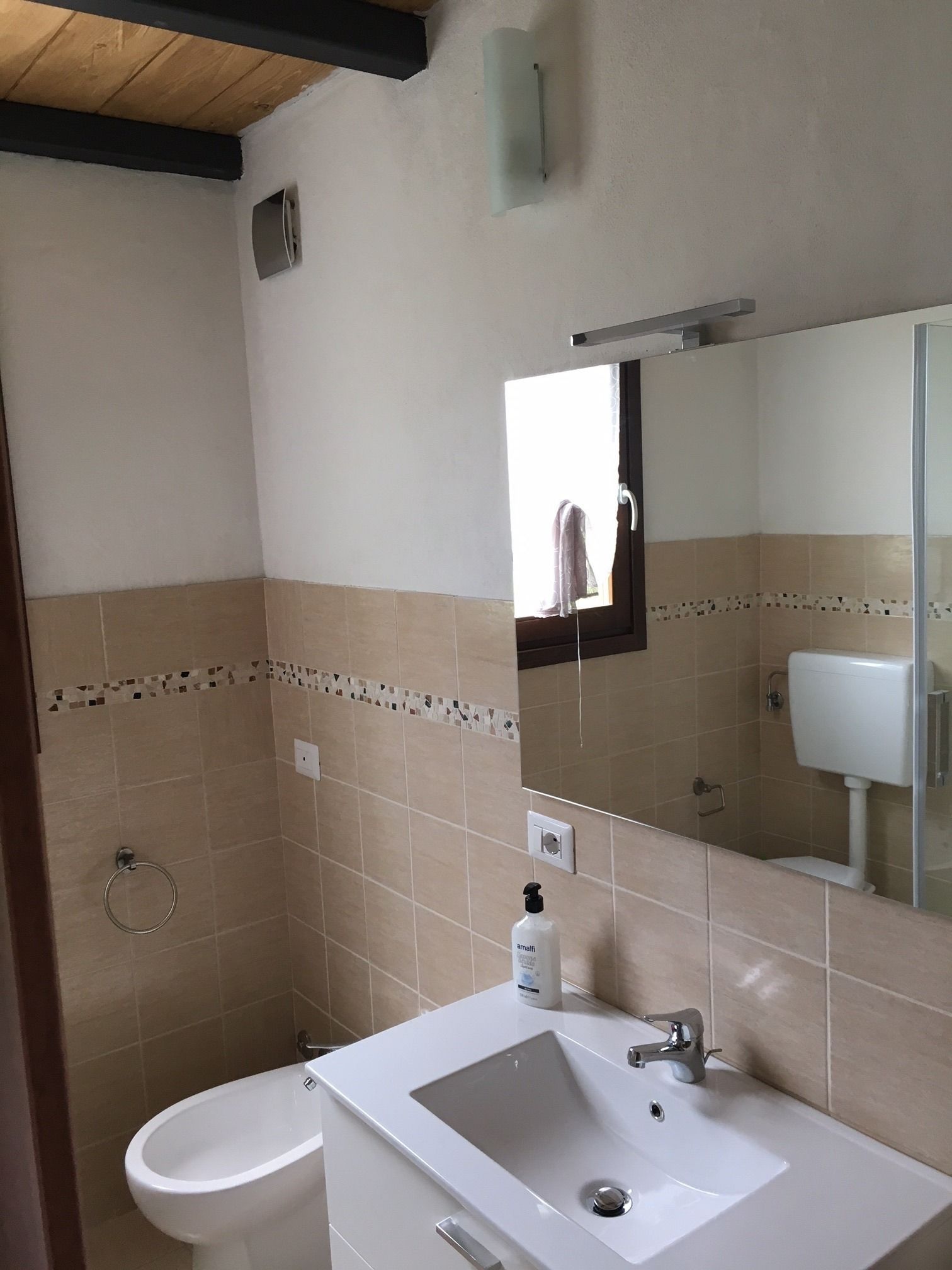 A bathroom with a white sink, a toilet, and a shower area.
